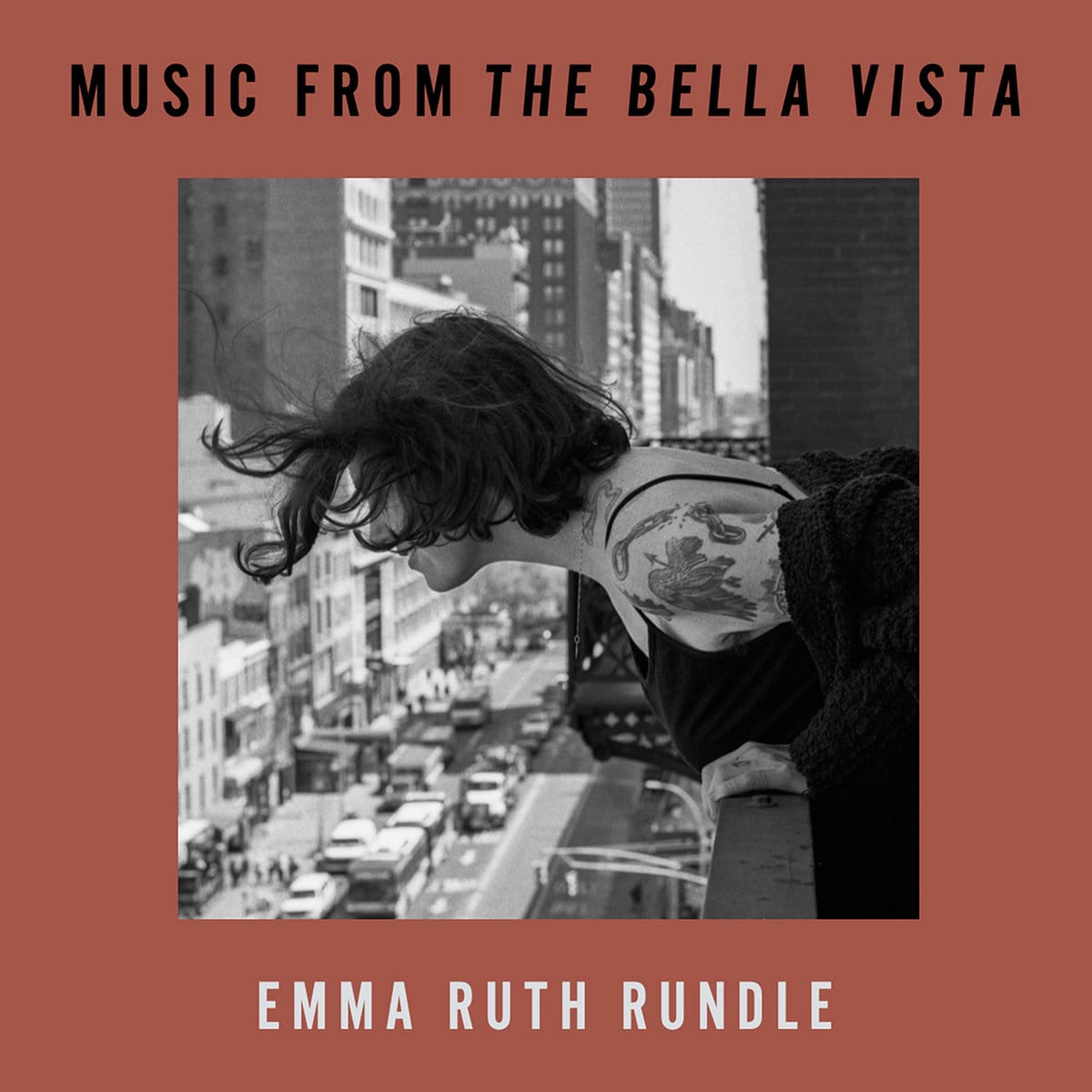 The cover for Emma Ruth Rundle's Music From The Bella Vista. A black and white photo of Emma leaning over a balcony overlooking a city street